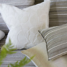 Indlæs billede til gallerivisning Quilted white pillow and patterned gray pillow on a striped sofa with a plant in the foreground.