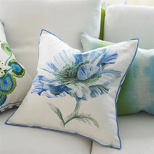 Load image into Gallery viewer, A square white throw pillow with a blue watercolor floral print and blue piping, styled on a white sofa alongside other decorative pillows.