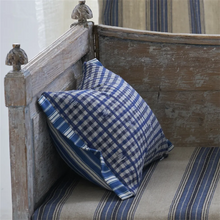 Load image into Gallery viewer, Blue and white checkered pillow on a wooden bench with striped cushions.